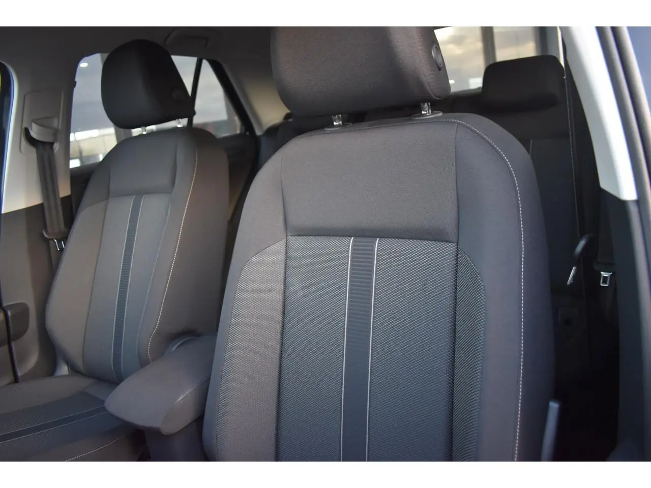 Gros plan sur les sièges avant en tissu noir titane et gris du Volkswagen T-Roc 2025, intérieur lumineux.