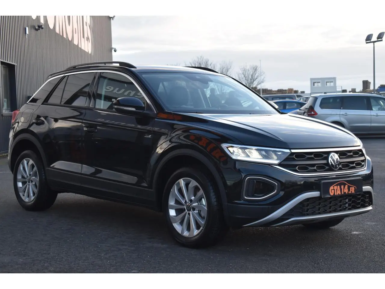 Volkswagen T-Roc 2025 noir grenadilla en 3/4 avant droit avec jantes alliage 17 pouces et calandre distinctive.