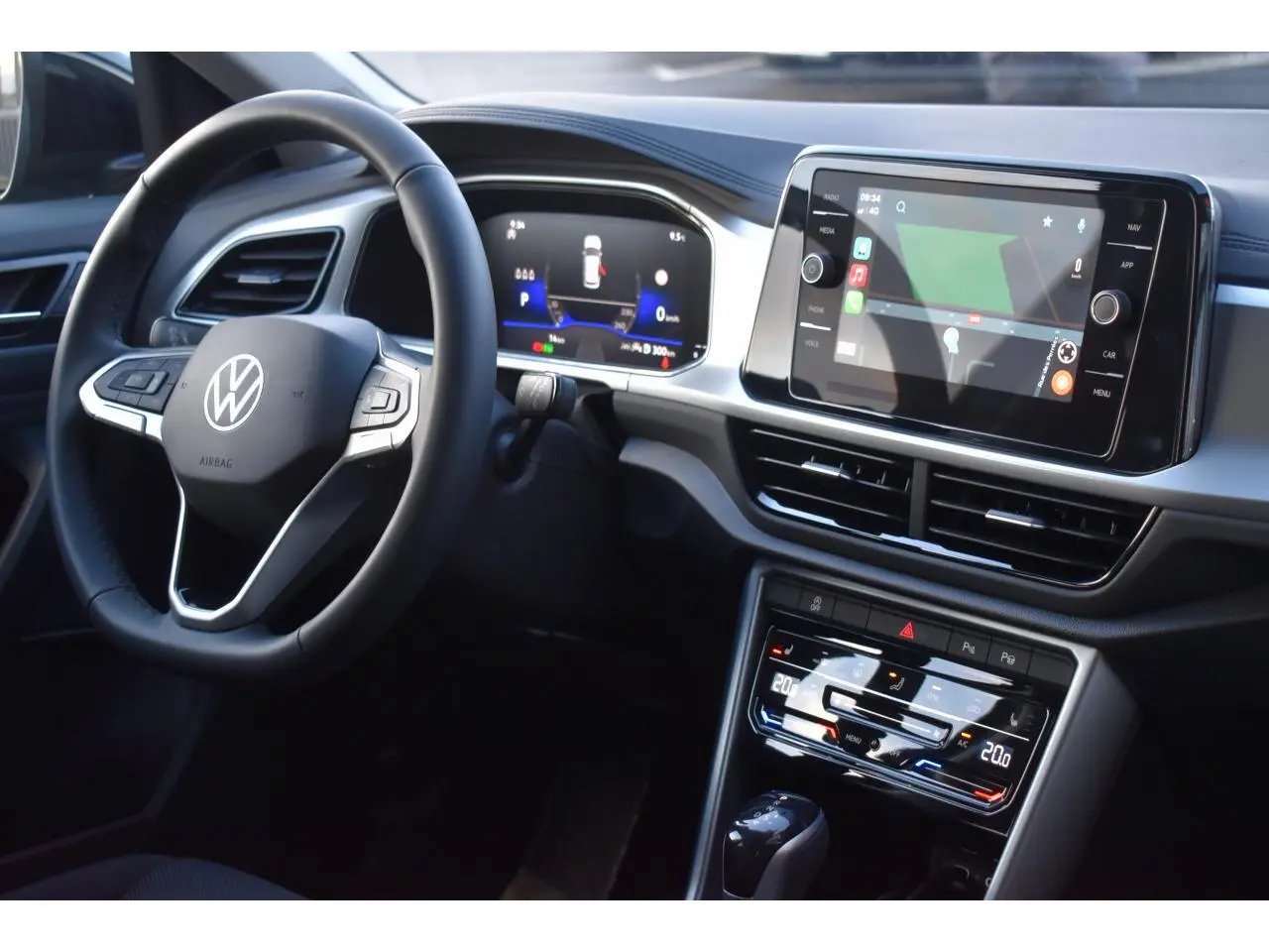 Vue intérieure du tableau de bord du Volkswagen T-Roc 2025, avec volant multifonction et écran tactile central.