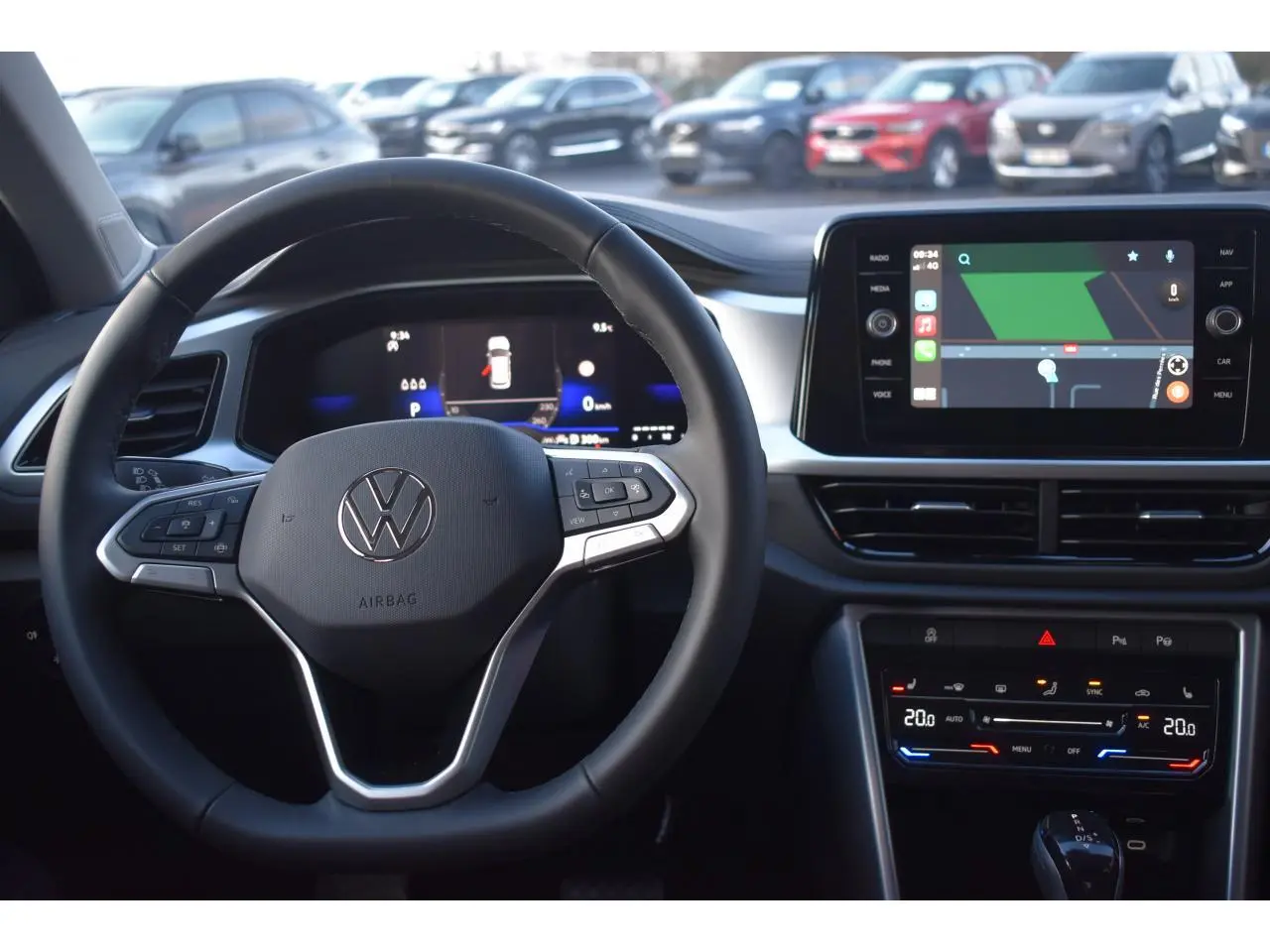 Vue intérieure centrée sur le volant Volkswagen T-Roc avec tableau de bord digital et écran tactile multimédia.