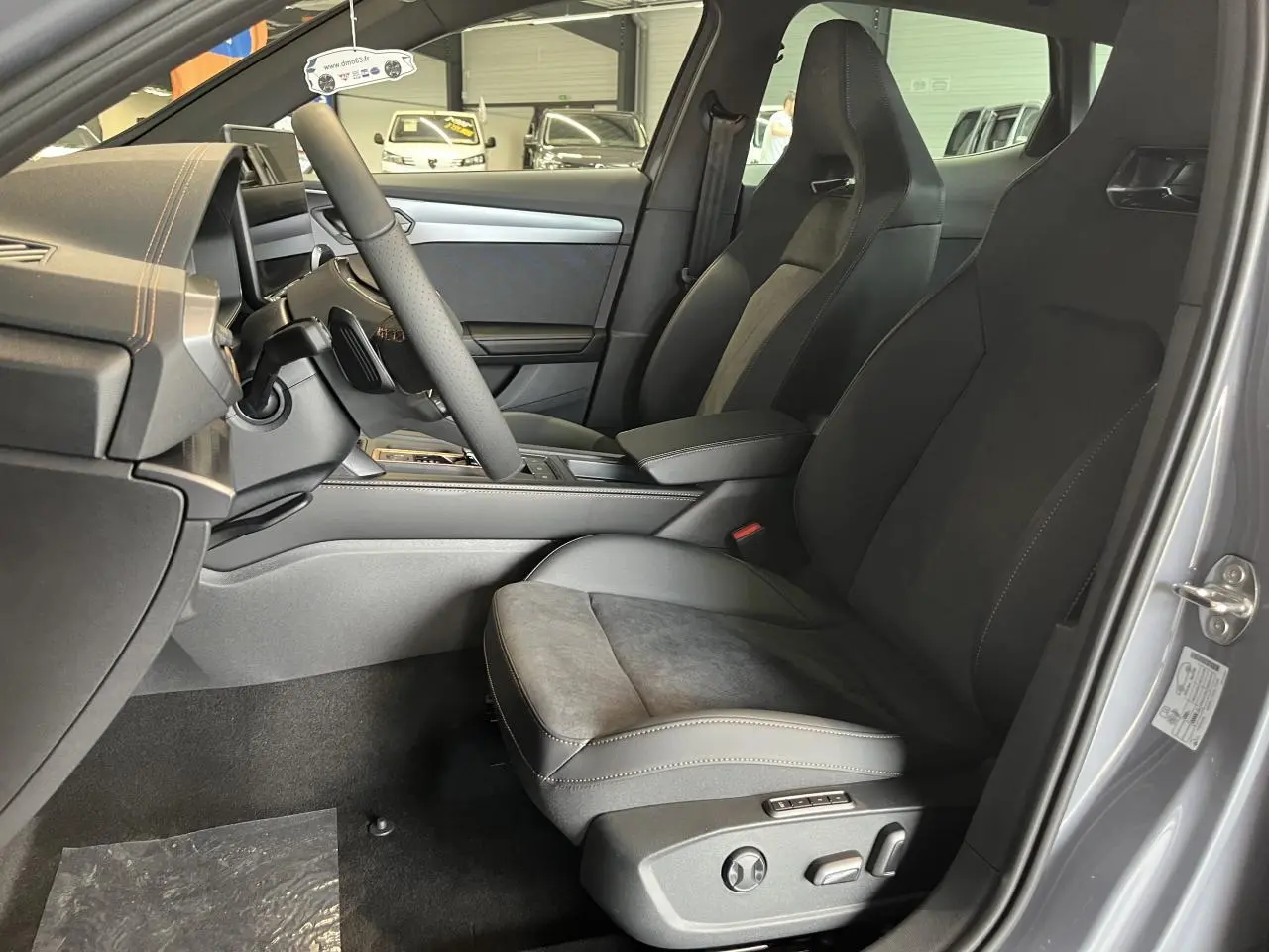Vue intérieure côté conducteur du CUPRA Formentor gris clair 2025, sièges sport en cuir et alcantara avec surpiqûres contrastantes.