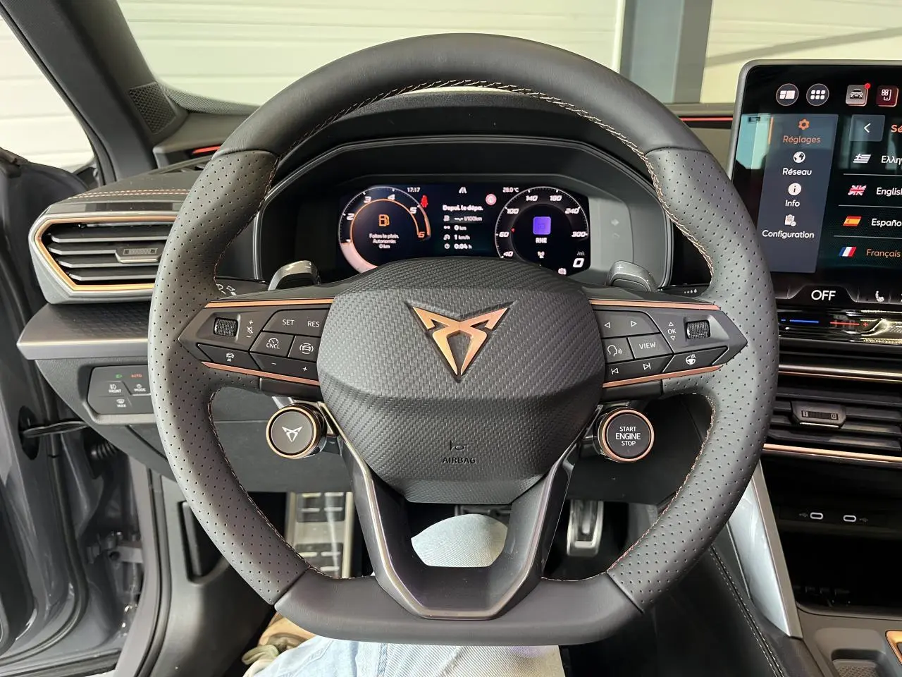 Vue frontale du volant perforé noir avec logo CUPRA cuivré et tableau de bord digital du CUPRA Formentor 2025.