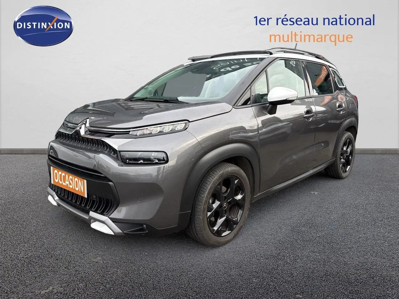 Citroën C3 Aircross gris platinium en 3/4 avant droit, avec jantes noires et rétroviseurs blancs.