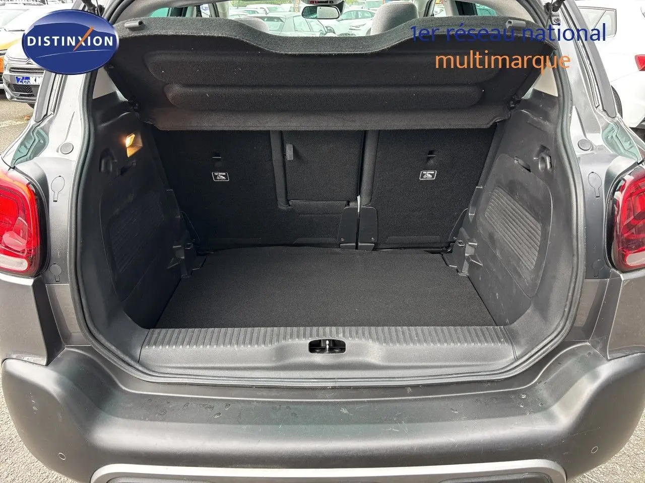 Coffre ouvert vu de l’arrière d’un Citroën C3 Aircross 2021 gris platinium, montrant l’espace de chargement vide.