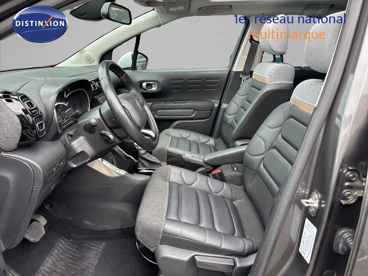 Vue intérieure côté conducteur du Citroën C3 Aircross gris platinium, sièges mixtes cuir et tissu avec détails beige.
