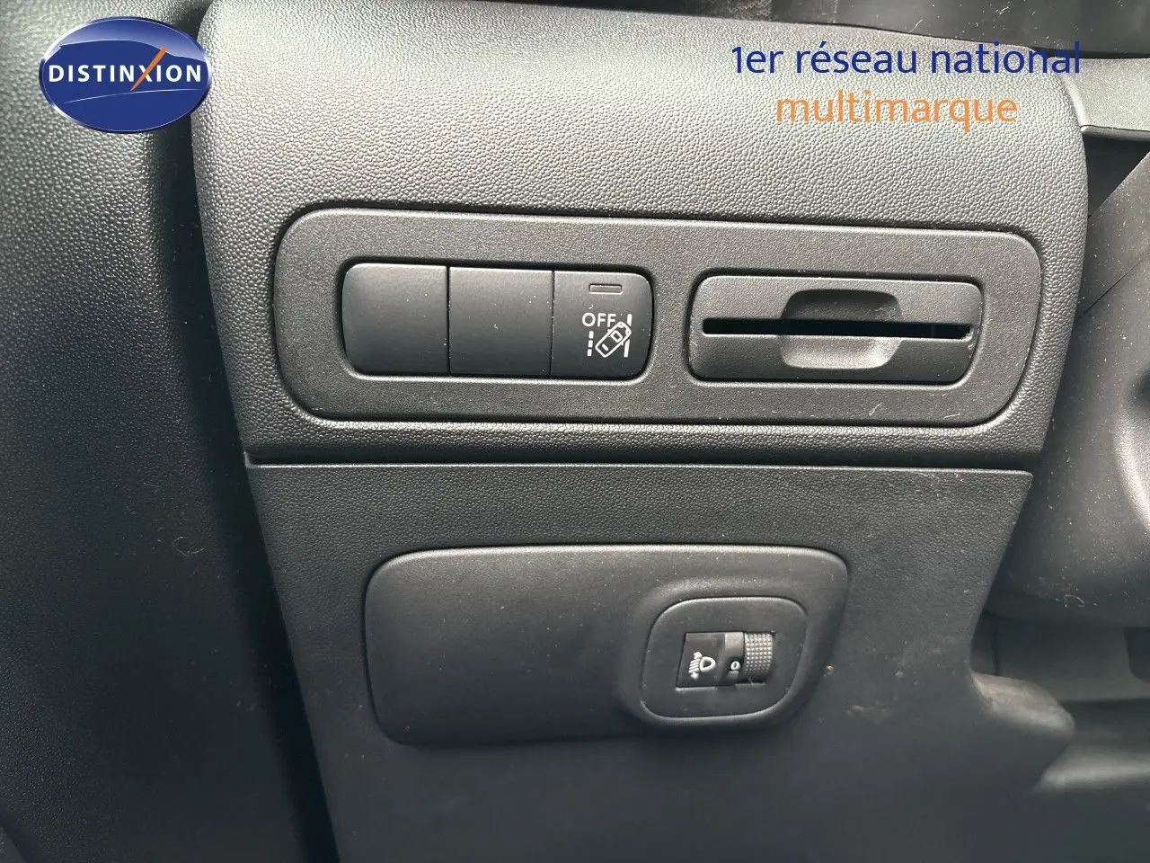 Détail intérieur montrant les commandes de réglage des phares et des fonctions sur la planche de bord noire du Citroën C3 Aircross.