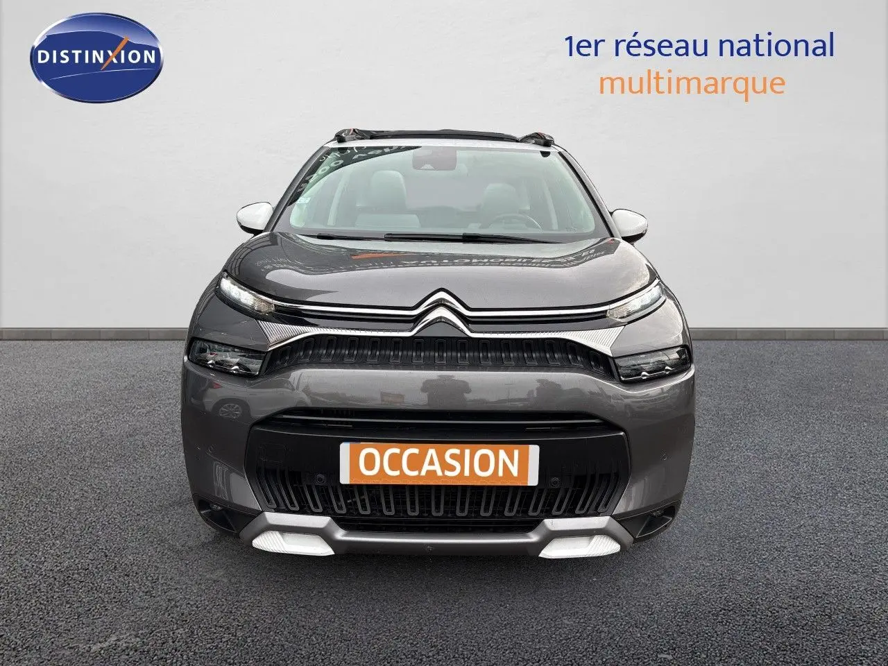 Vue avant d'un Citroën C3 Aircross gris platinium avec calandre noire et détails blancs sous le pare-chocs.