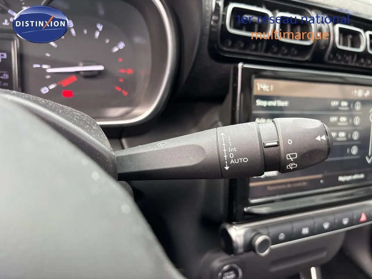Gros plan sur la commande d’essuie-glace à gauche du volant dans l’habitacle du Citroën C3 Aircross gris platinium.