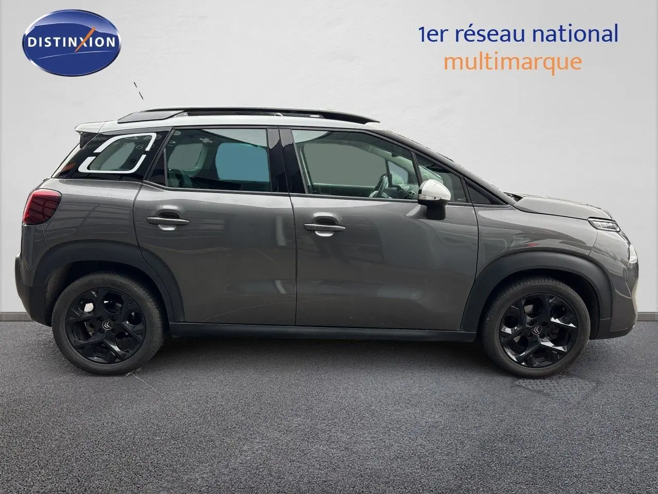 Profil droit d'une Citroën C3 Aircross Shine gris platinium avec toit noir et jantes noires, vue extérieure latérale.