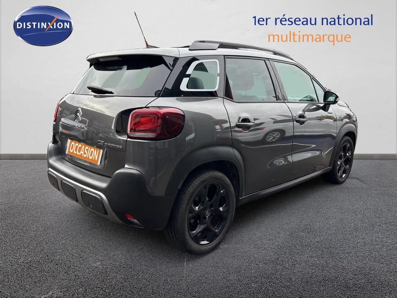 Vue 3/4 arrière droite d'une Citroën C3 Aircross Shine gris platinium avec jantes noires et toit noir.