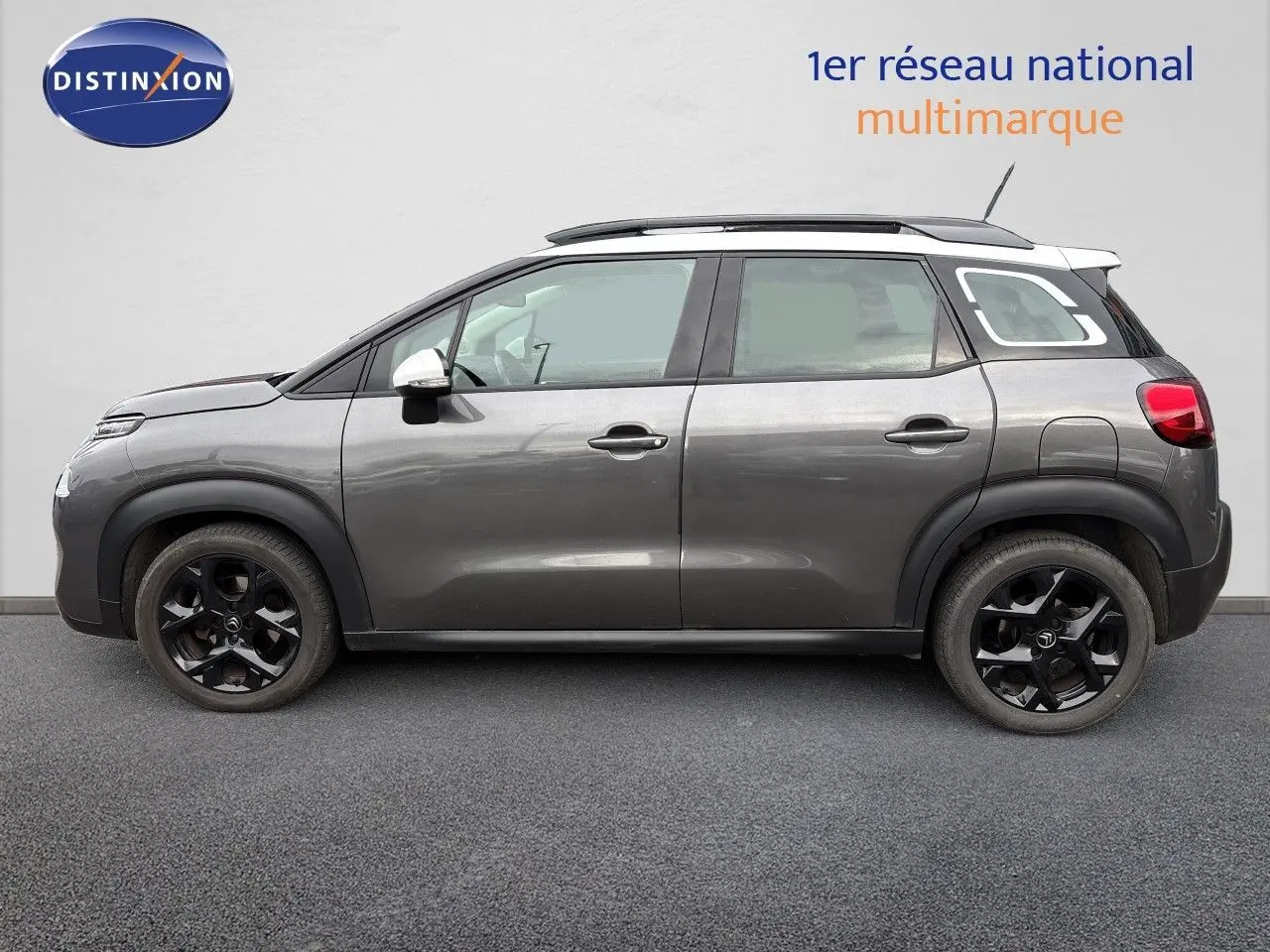 Profil droit d'une Citroën C3 Aircross gris platinium avec toit blanc et jantes noires, vue sur fond neutre.