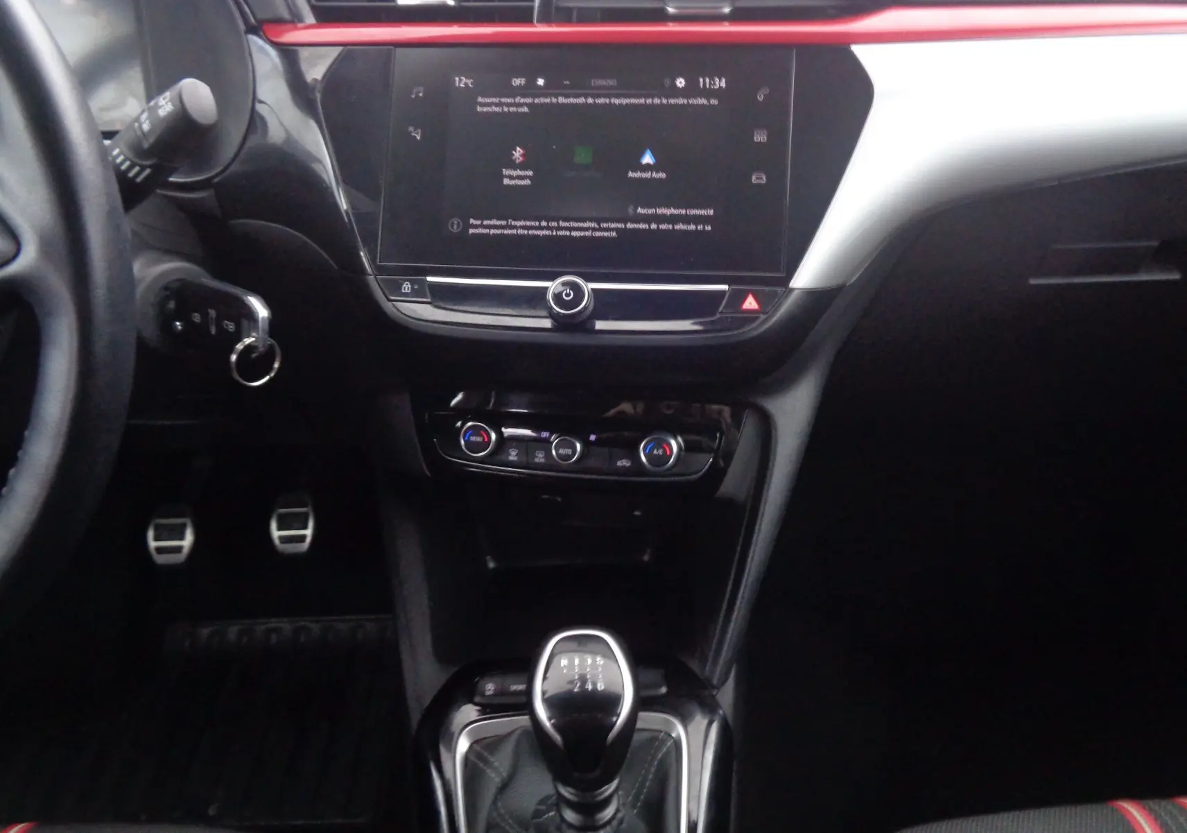Vue intérieure centrée sur la console centrale et levier de vitesses d'une Opel Corsa rouge Kardio 2021 finition GS-Line.