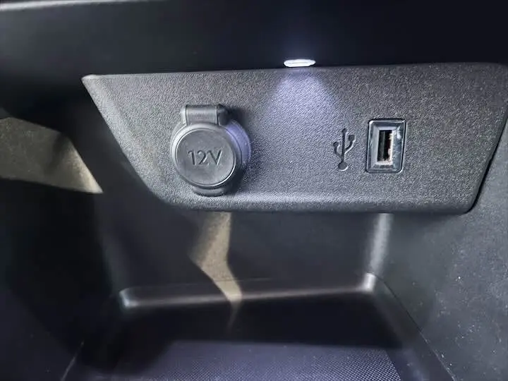Prise 12V et port USB en gros plan dans l'habitacle noir de l'Opel Corsa rouge Kardio 2021.