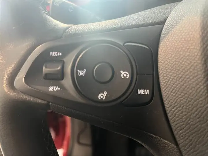 Gros plan sur les commandes de régulateur de vitesse au volant d'une Opel Corsa rouge Kardio, version 2021.
