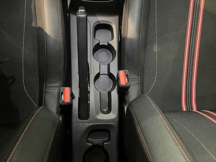 Vue plongeante sur la console centrale et les sièges noirs avec surpiqûres rouges de l’Opel Corsa rouge Kardio.