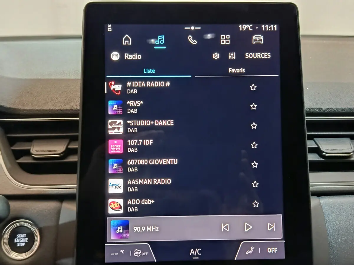 Écran tactile central du tableau de bord du Renault Captur blanc 2025 affichant les stations radio DAB.