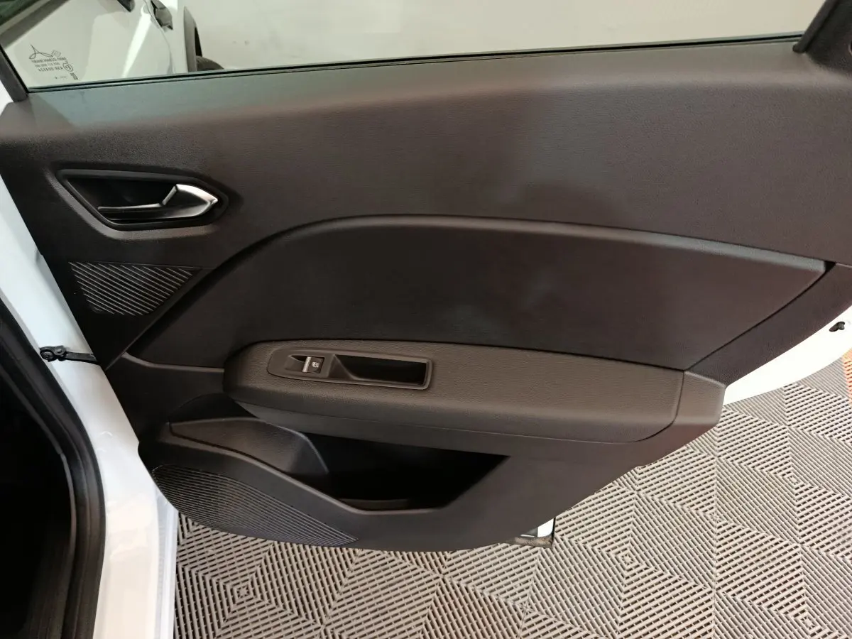 Vue intérieure de la porte côté gauche noire du Renault Captur blanc 2025 avec poignée et commande de fenêtre électrique.