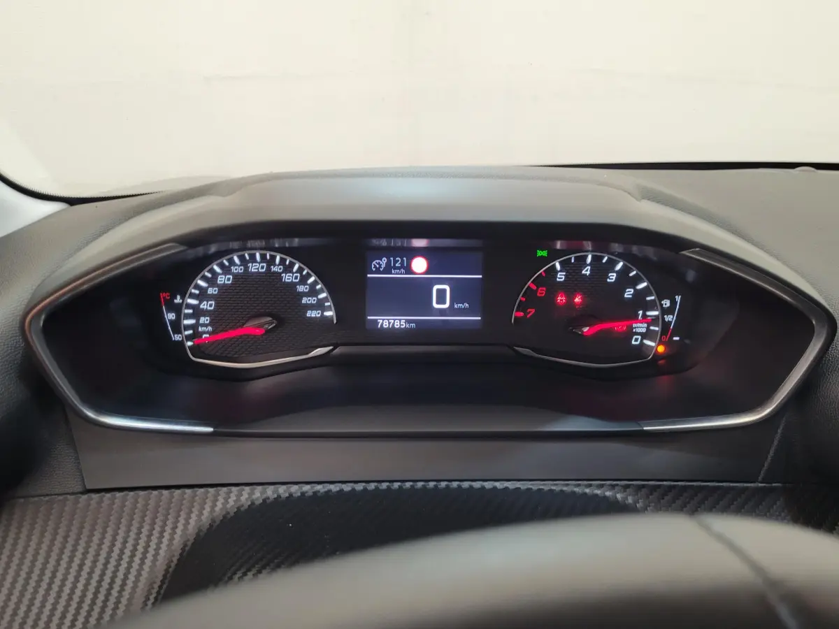 Tableau de bord de Peugeot 208 gris foncé 2023, affichage numérique central et compte-tours analogique rouge.