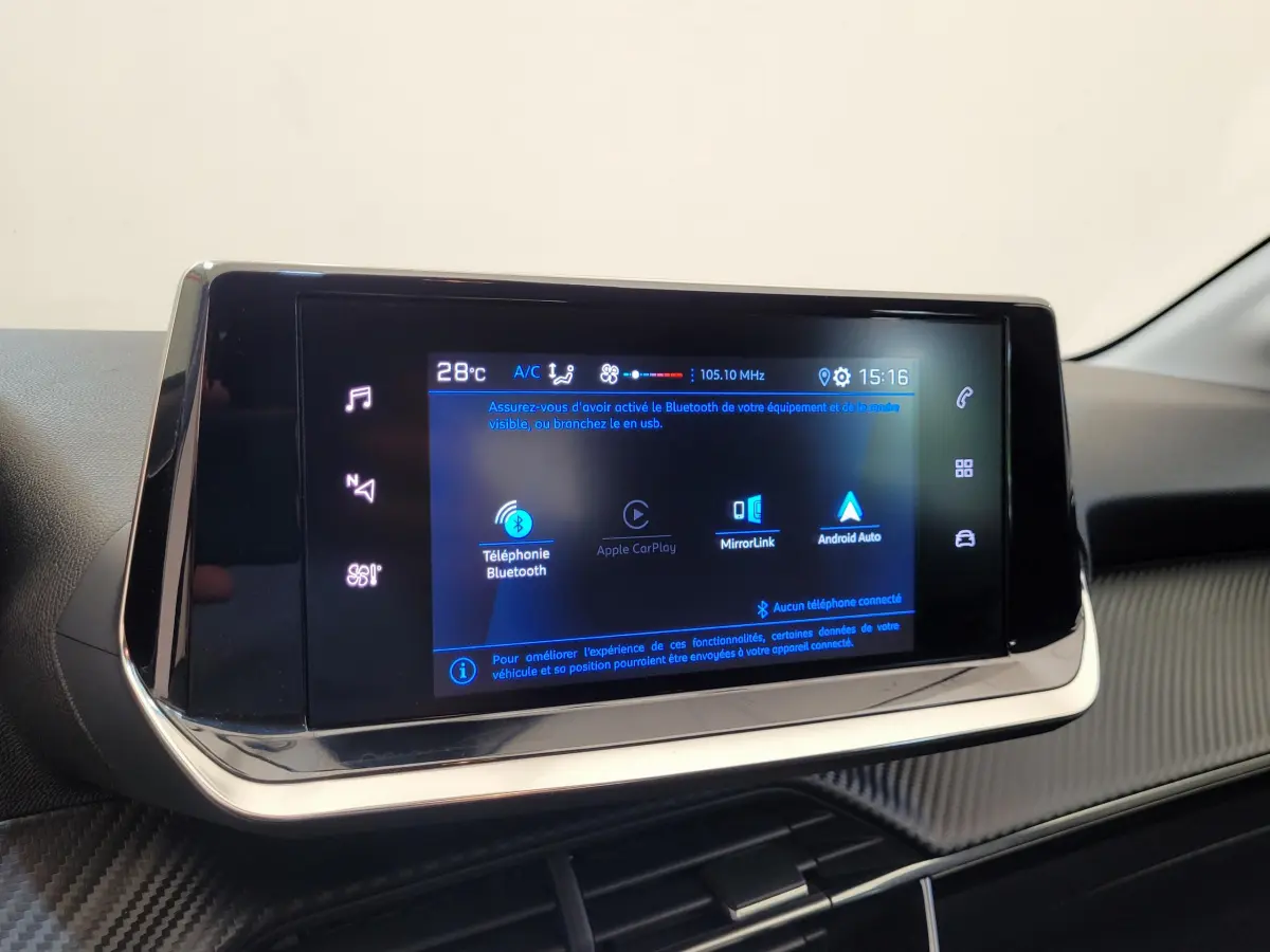 Écran tactile central allumé affichant les options Bluetooth et Android Auto dans l'habitacle d'une Peugeot 208 2023.