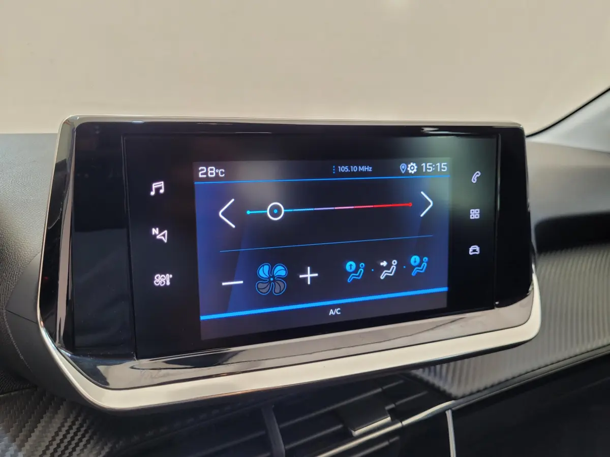 Écran tactile central affichant la climatisation dans l'habitacle d'une Peugeot 208 gris foncé, vue de face.