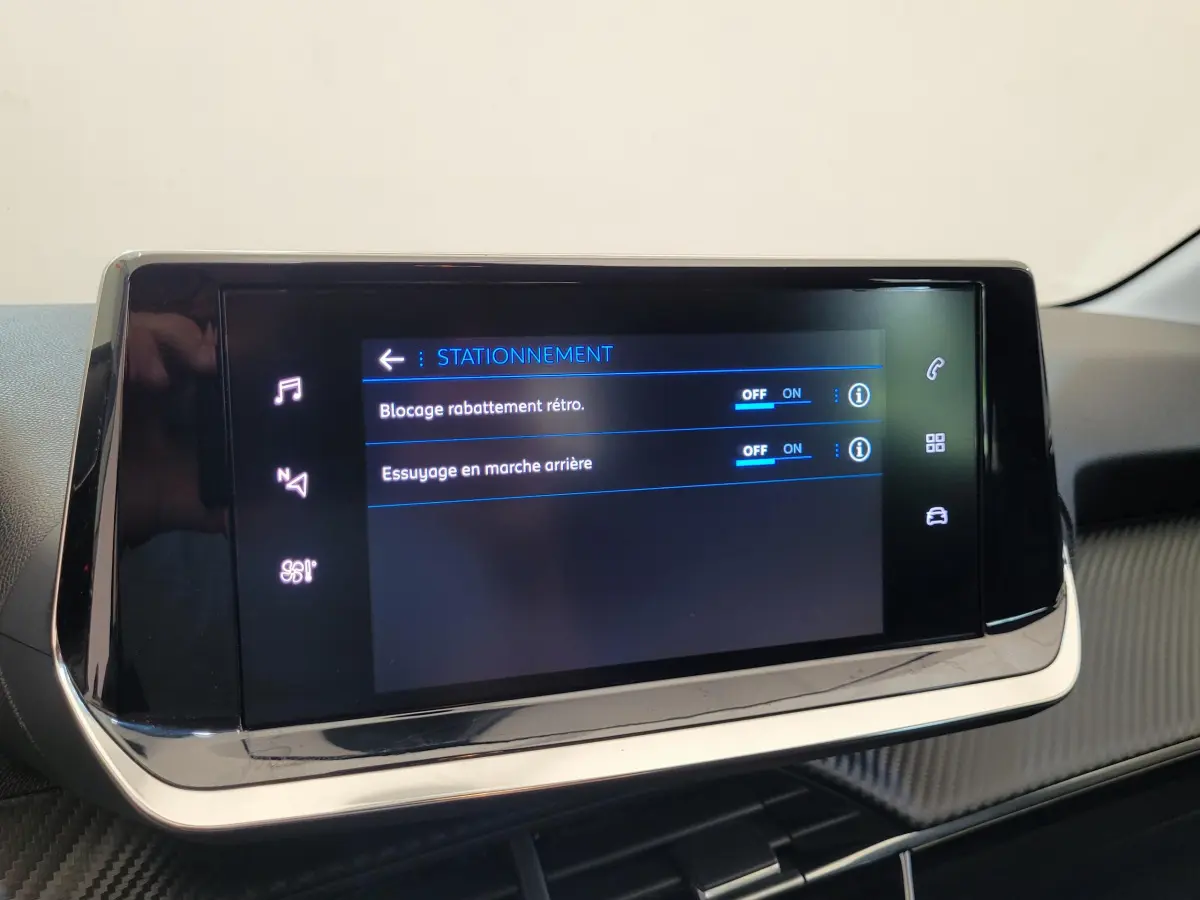 Écran tactile central de la Peugeot 208 gris foncé 2023 affichant les options de stationnement et rétroviseurs.
