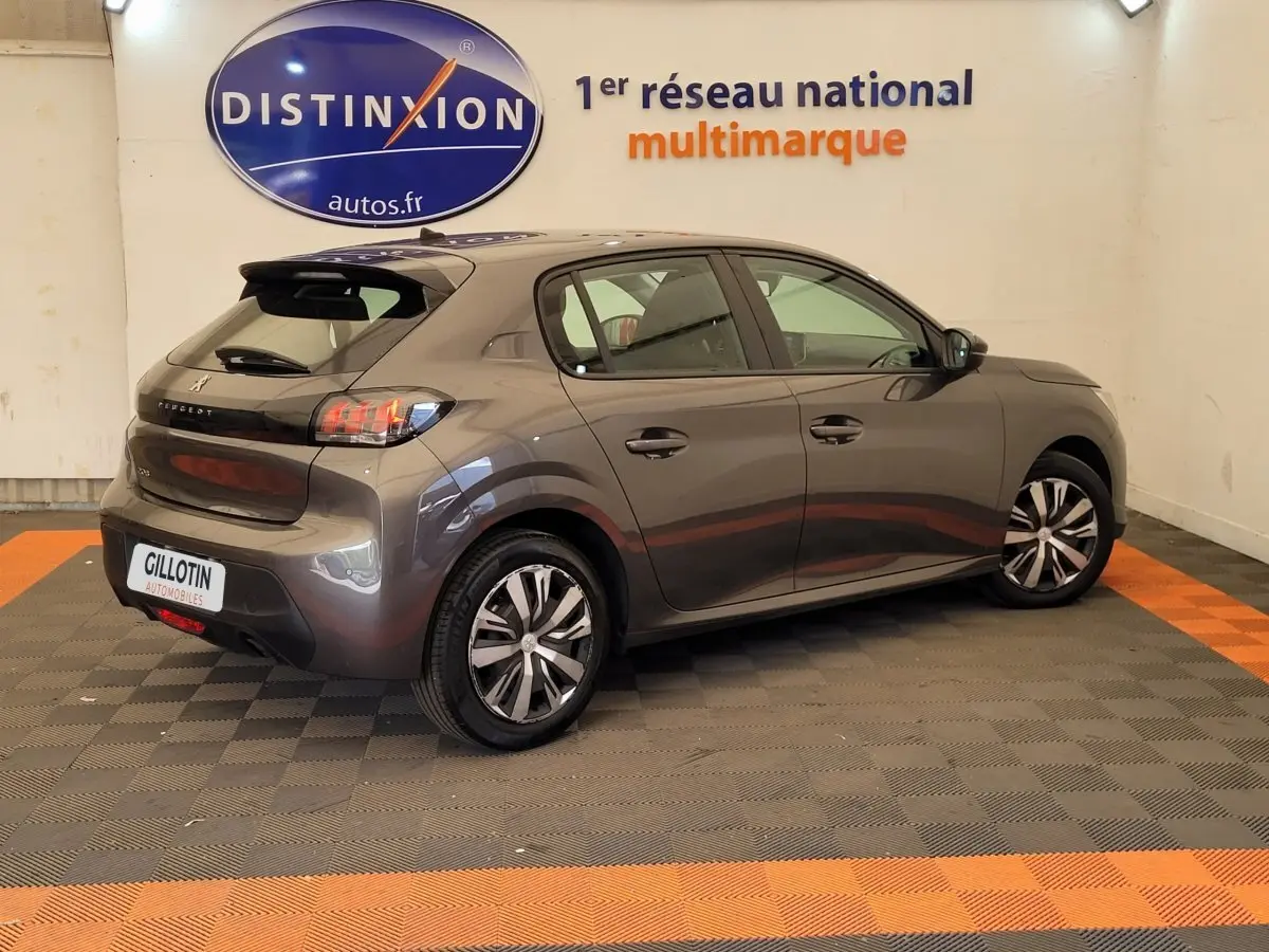 Vue 3/4 arrière droite d'une Peugeot 208 gris foncé avec feux arrière LED et jantes alliage modernes.