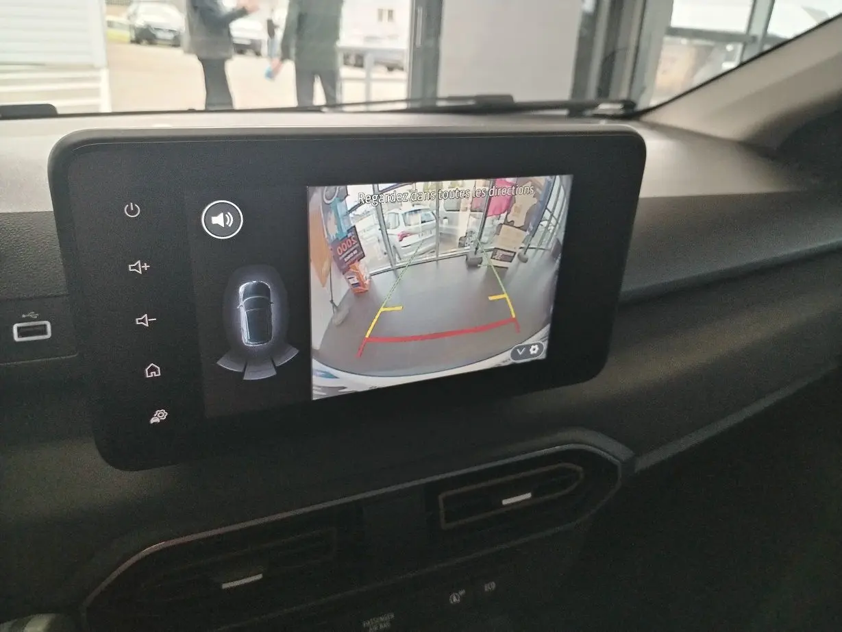 Écran central du tableau de bord du Dacia Jogger blanc 2025 montrant la caméra de recul avec guidage coloré.