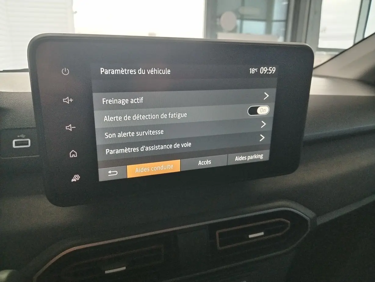 Écran tactile central du tableau de bord du Dacia Jogger blanc, affichant les paramètres d’aides à la conduite.