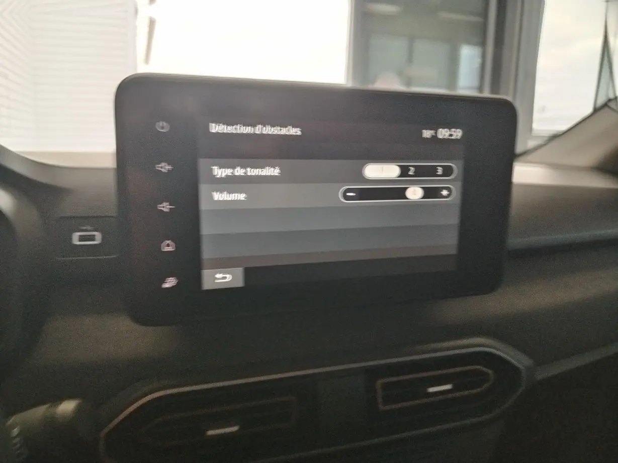 Écran tactile central affichant les réglages de détection d'obstacles dans l'habitacle du Dacia Jogger blanc.