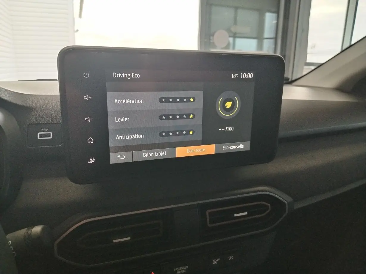 Écran tactile central affichant le score éco-conduite dans l'habitacle du Dacia Jogger 2025 blanc.