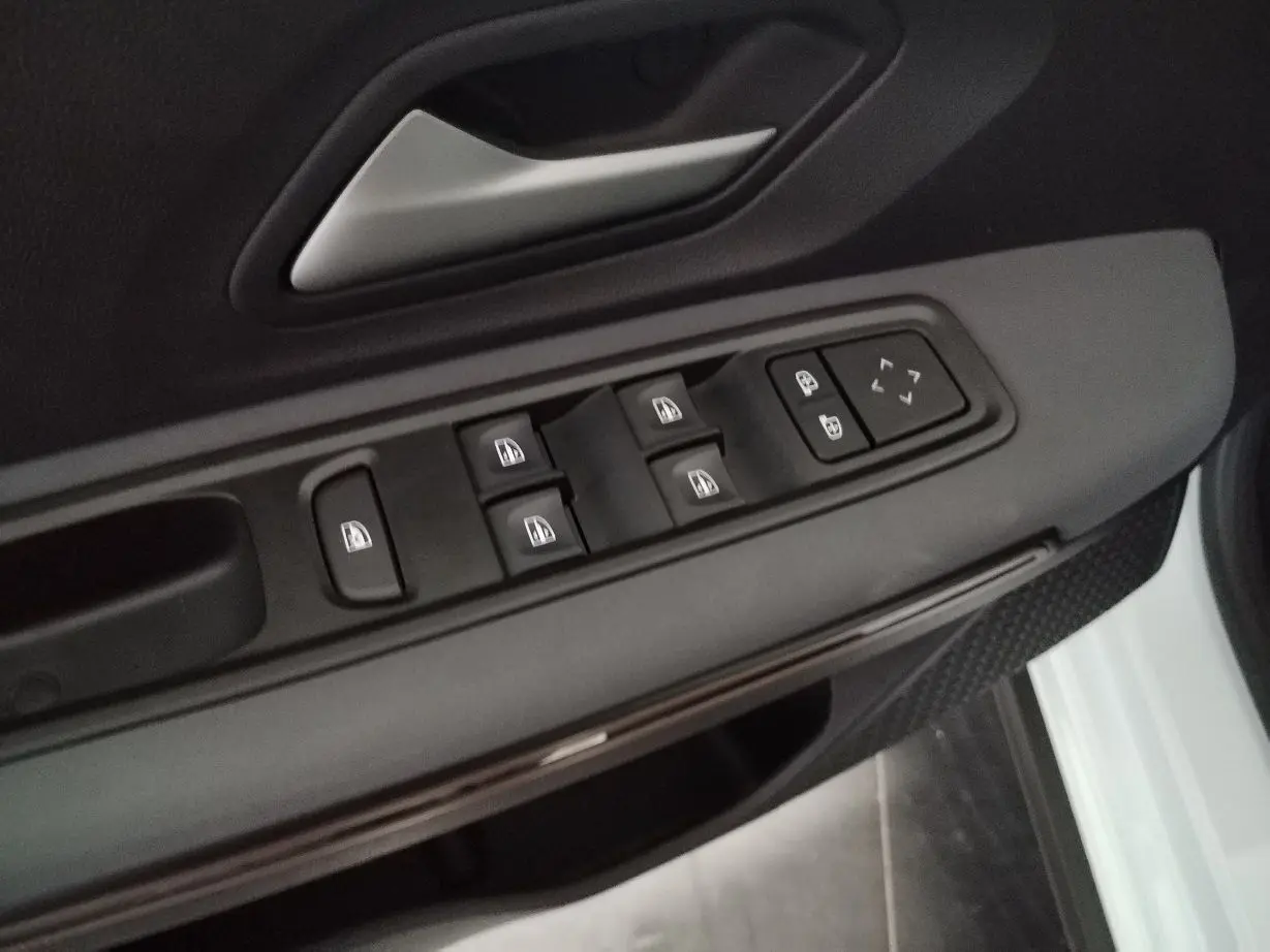 Commande des vitres et réglages des rétroviseurs sur la portière côté conducteur d'un Dacia Jogger blanc 2025.