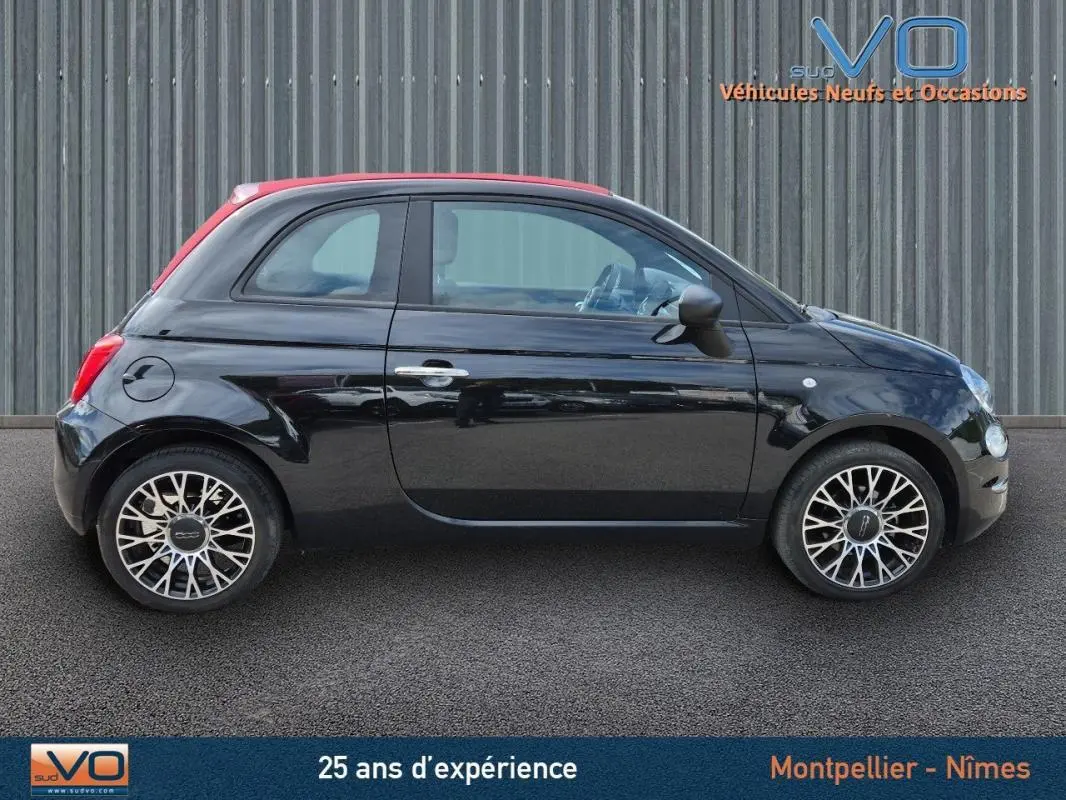 Profil côté droit de la FIAT 500C noire 2024 avec toit rouge et jantes stylisées, vue sur roue de secours intégrée.