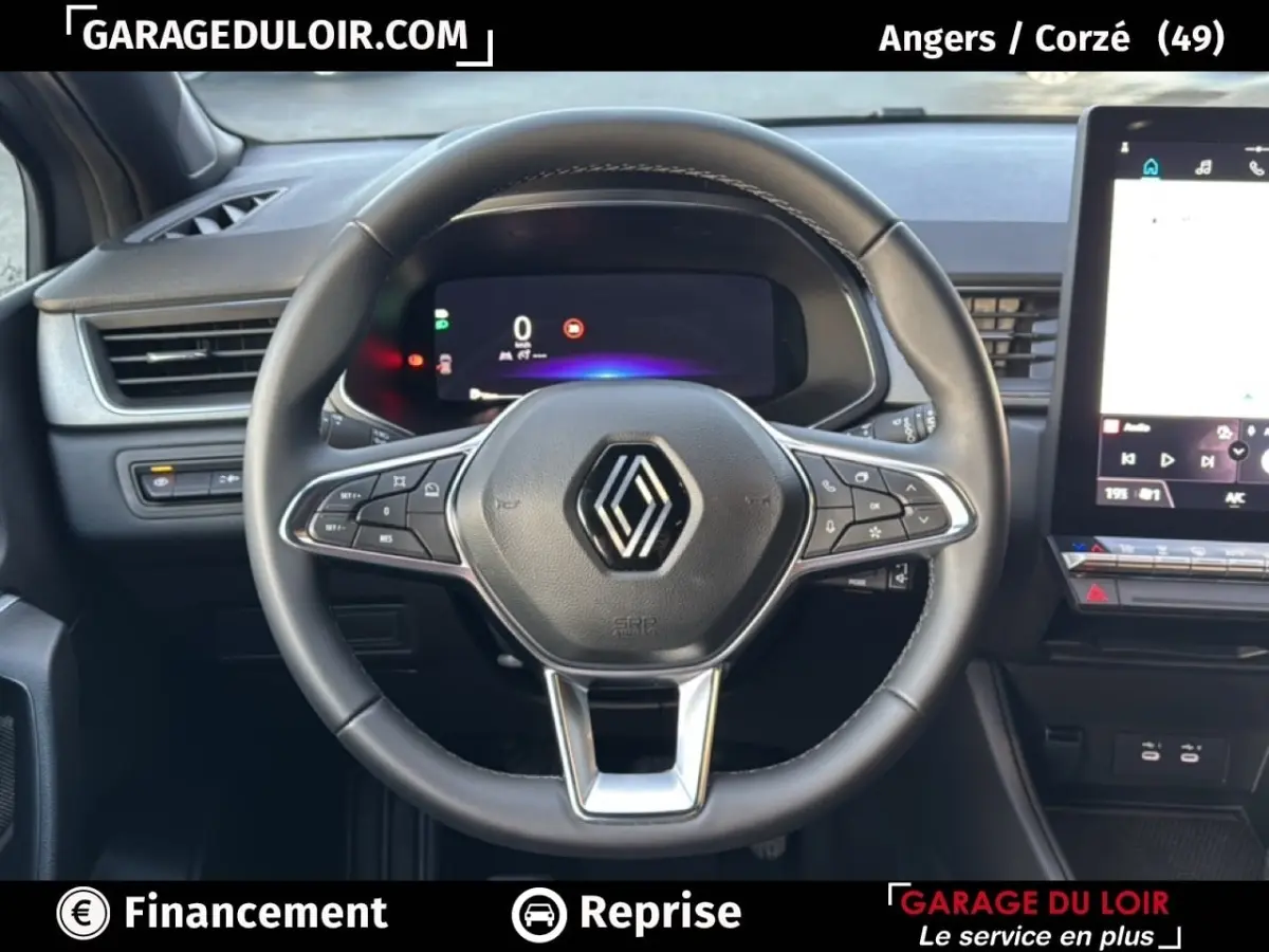 Vue intérieure centrée sur le volant du Renault Captur 2025, avec tableau de bord numérique et écran tactile visible.