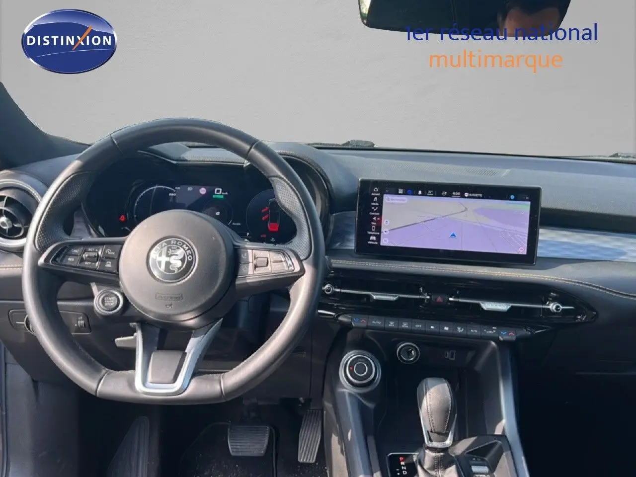 Vue intérieure du poste de conduite de l'Alfa Romeo Tonale gris Vesuvio, avec volant, tableau de bord digital et écran central tactile.