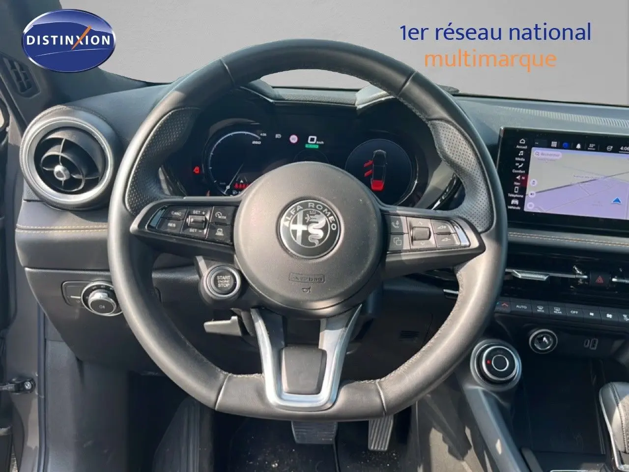 Vue intérieure centrée sur le volant Alfa Romeo Tonale 2023, tableau de bord numérique et écran tactile avec navigation.