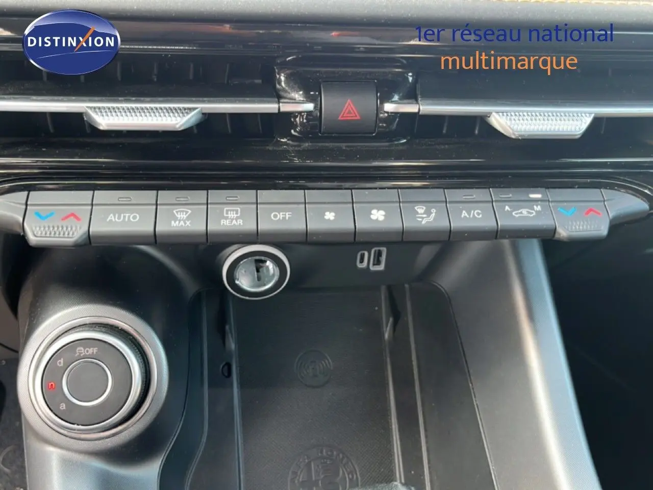 Vue rapprochée de la console centrale de l'Alfa Romeo Tonale gris Vesuvio, montrant les commandes de climatisation et la molette de sélection.