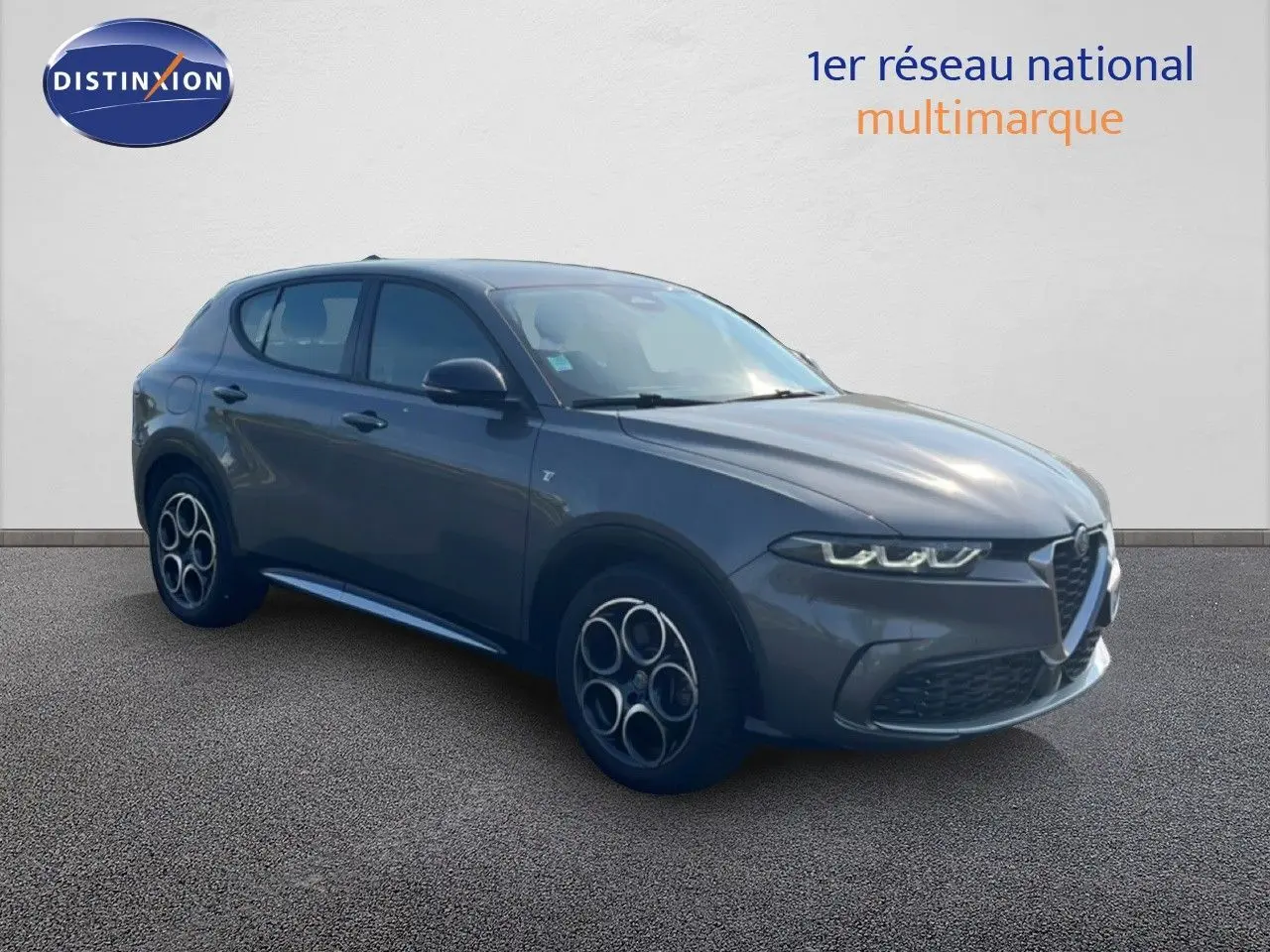 Vue 3/4 avant gauche d'une Alfa Romeo Tonale 1.5 Hybrid 160ch gris Vesuvio métallisé avec jantes distinctives.