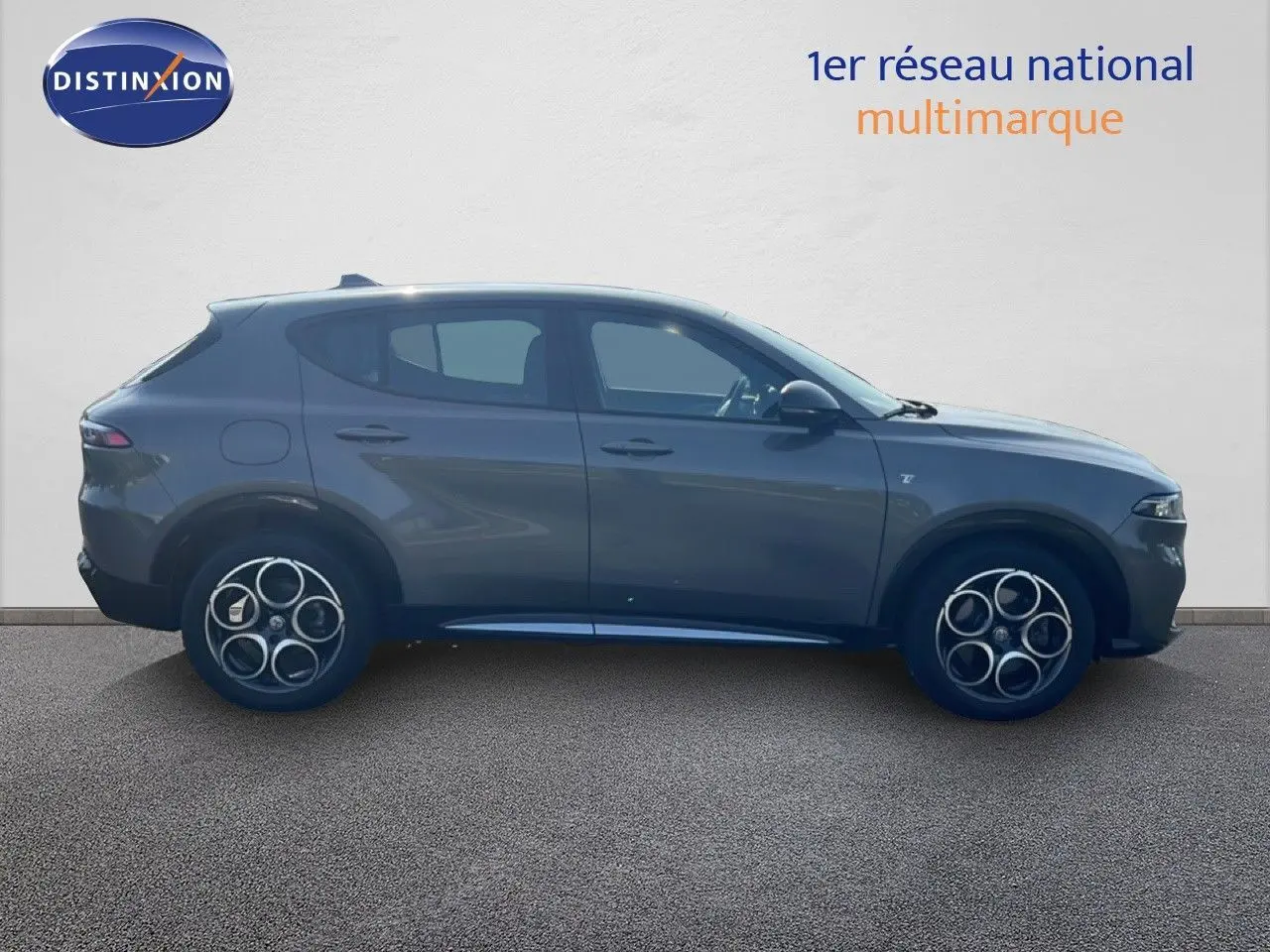 Vue latérale droite d'un Alfa Romeo Tonale gris Vesuvio métallisé, soulignant ses jantes distinctives et sa silhouette compacte.