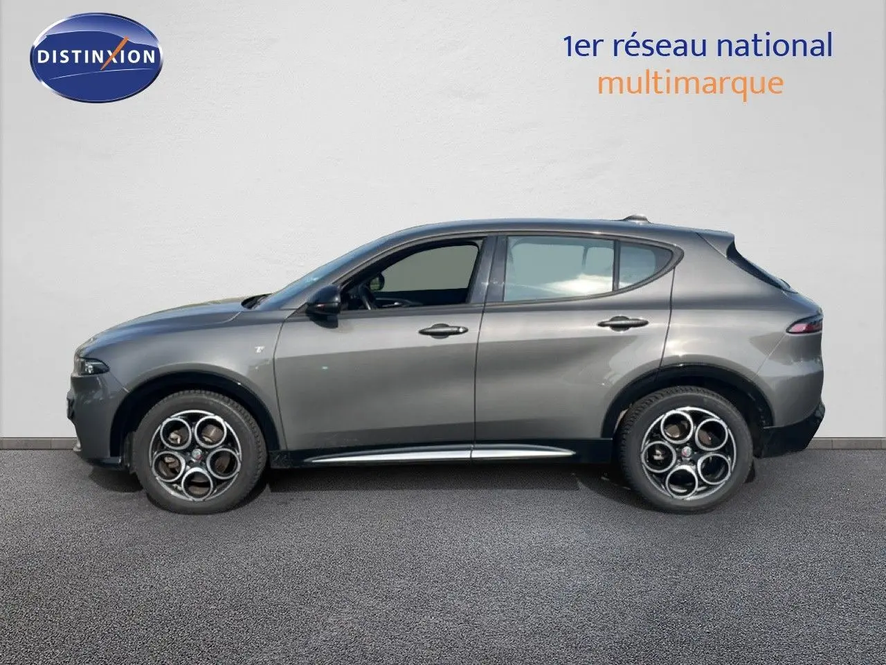 Vue de profil côté gauche d'un Alfa Romeo Tonale gris Vesuvio métallisé avec jantes distinctives à cinq cercles.