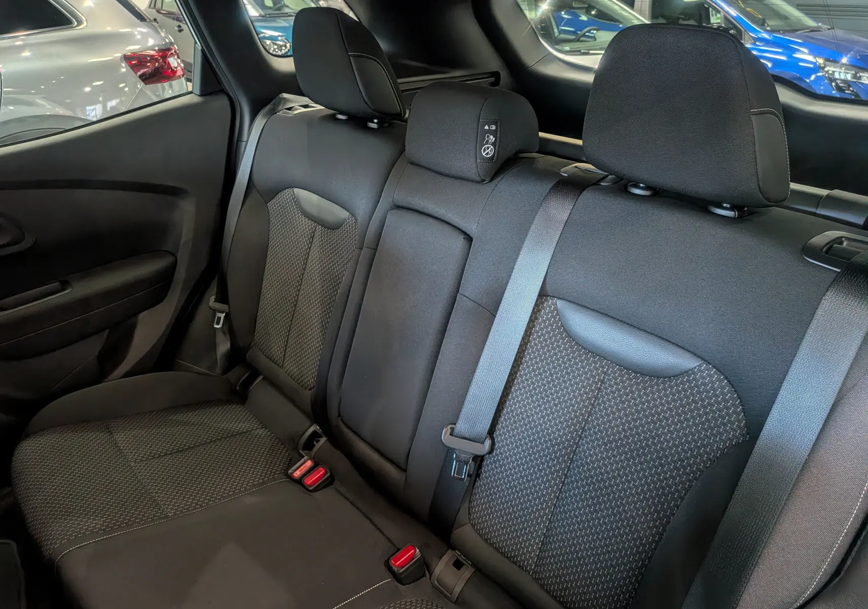 Vue intérieure du siège arrière droit du Renault Kadjar 2021, tissu noir avec ceintures de sécurité visibles.