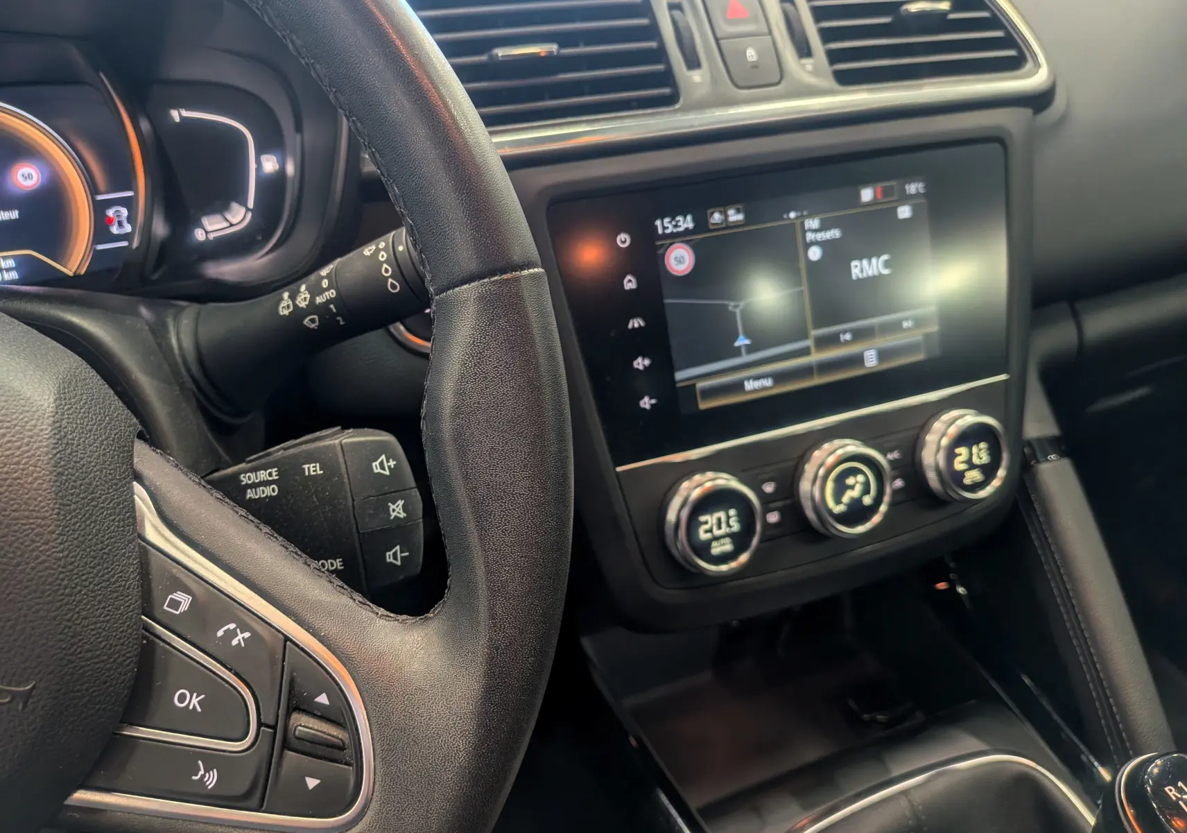 Vue intérieure rapprochée du tableau de bord et du volant noir du Renault Kadjar 2021 avec écran tactile et commandes climatiques.