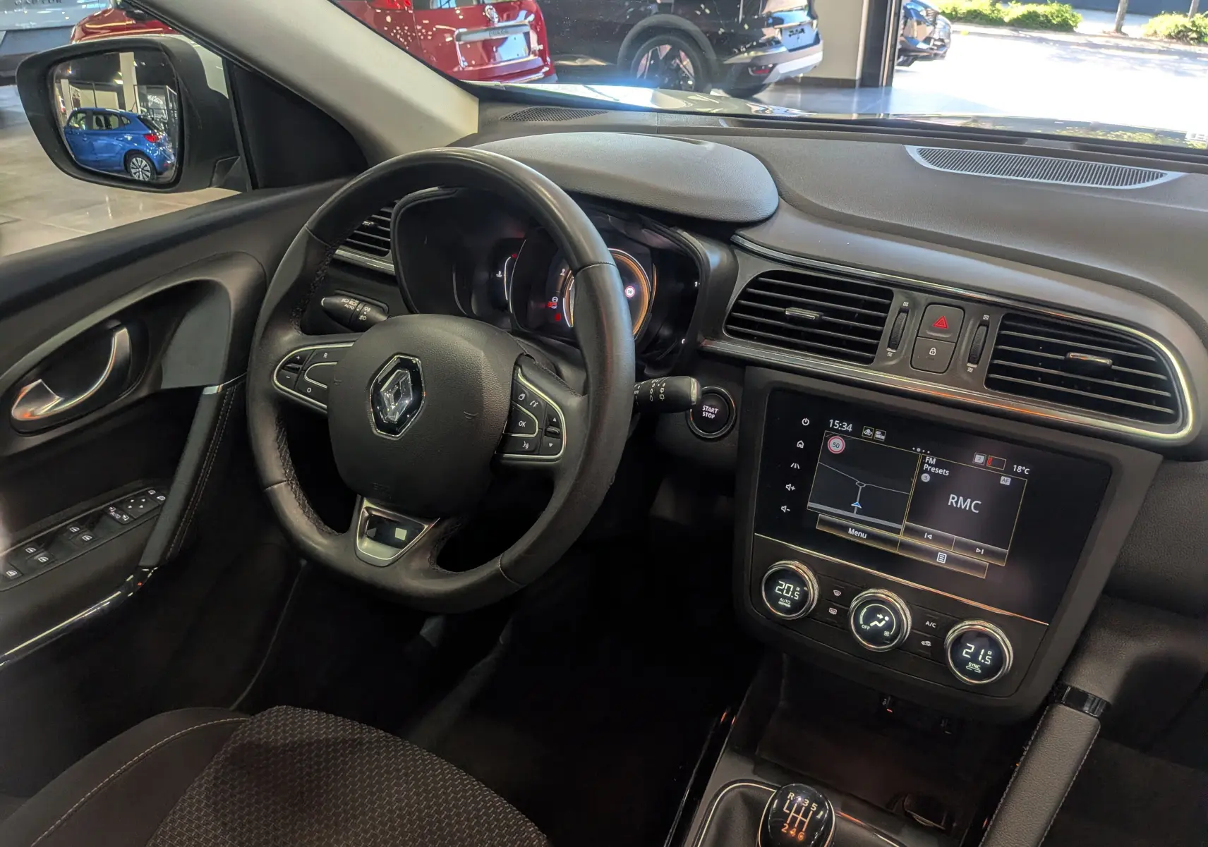 Vue intérieure côté conducteur du Renault Kadjar 2021, tableau de bord noir avec écran tactile et volant multifonction.
