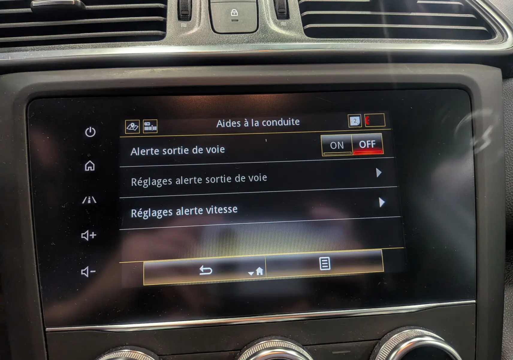 Écran tactile central du Renault Kadjar blanc glacier 2021 affichant les aides à la conduite, vue rapprochée de l'intérieur.