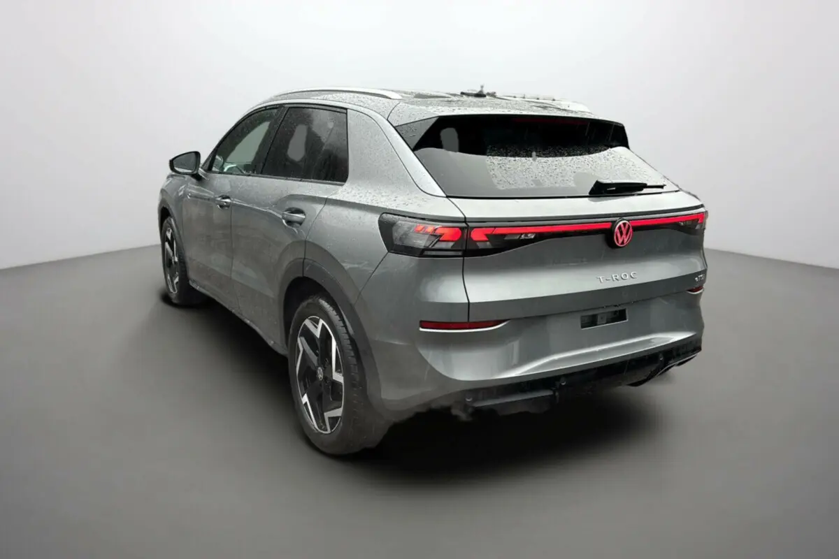 Volkswagen T-Roc gris loup en 3/4 arrière droit, avec feux arrière LED et jantes alu 18 pouces distinctives.