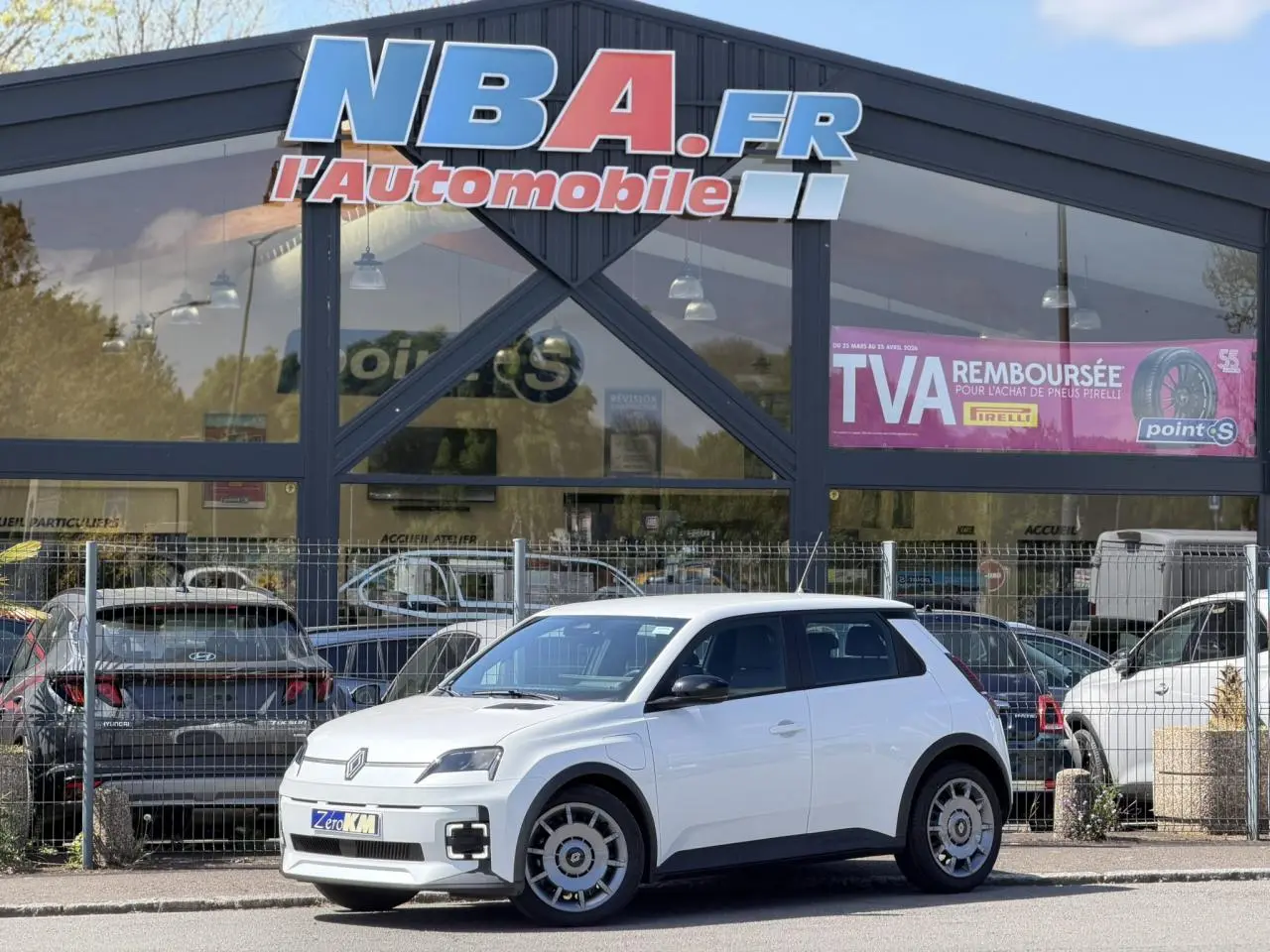 Renault R5 E-Tech blanc nacré vue 3/4 avant droit, avec jantes acier 18 pouces et signature lumineuse LED.