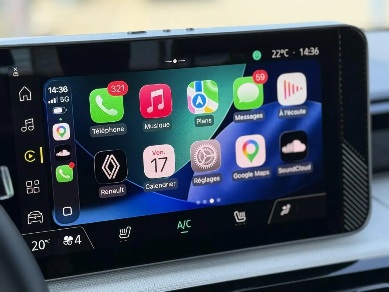 Écran tactile multimédia 10 pouces de la Renault R5 E-Tech blanc nacré, affichant Apple CarPlay et commandes climatisation.