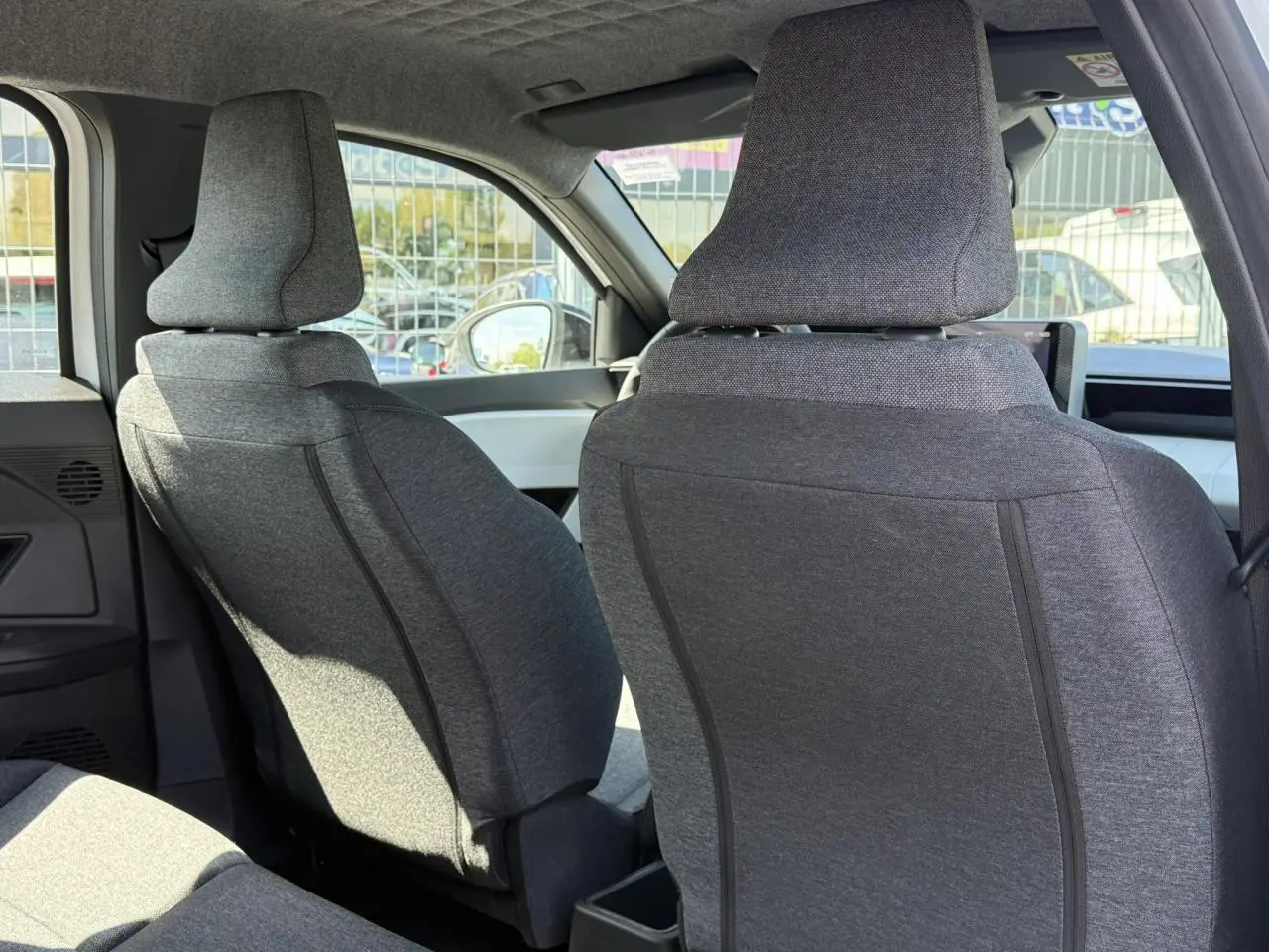 Vue arrière des sièges avant gris matelassés de la Renault R5 E-Tech Electrique 2026, intérieur lumineux et moderne.