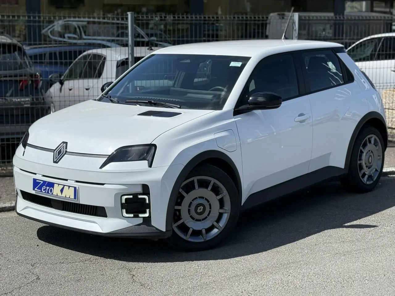 Renault R5 E-Tech blanc nacré vue 3/4 avant droit, avec phares et feux LED distinctifs et jantes acier 18 pouces.
