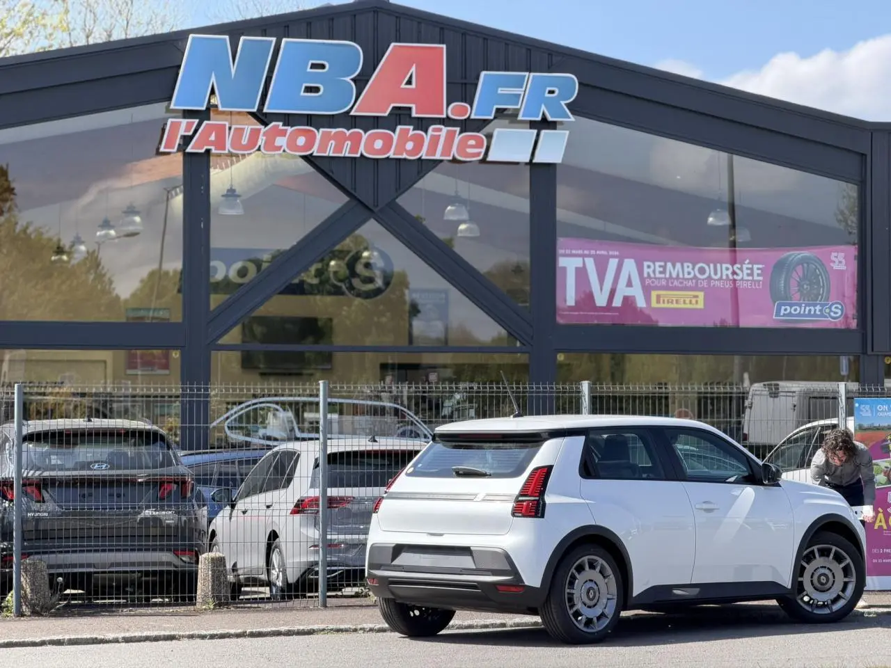 Vue 3/4 arrière droite de la Renault R5 E-Tech électrique blanc nacré, avec feux arrière LED et jantes acier 18 pouces.