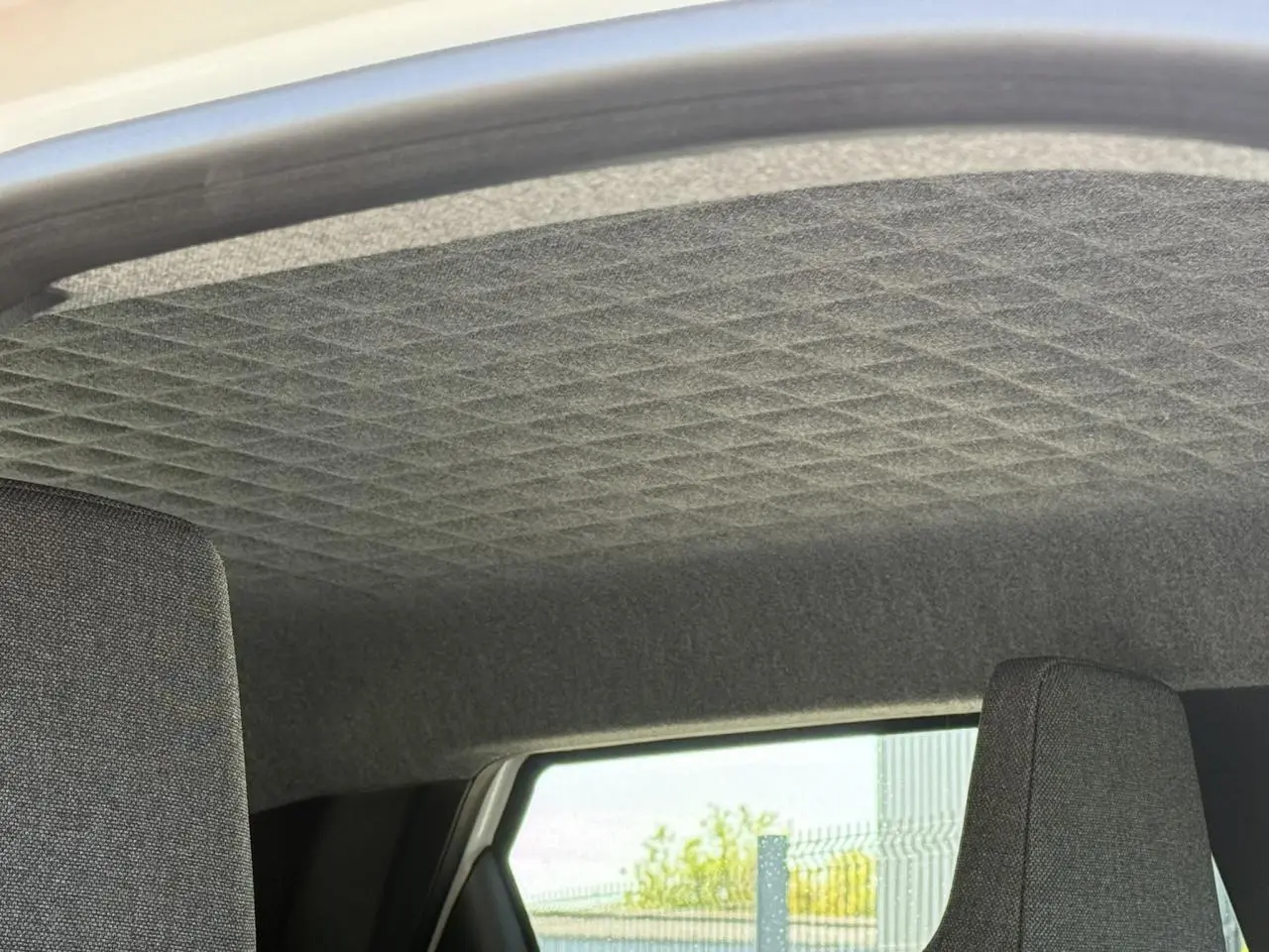 Intérieur de la Renault R5 E-Tech 2026, vue sur le ciel de toit gris matelassé et partie supérieure des sièges arrière.